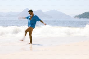 a man standing on a beach next to the ocean