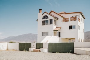 a large white house with a fence in front of it