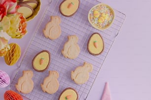 ein Tablett mit dekorierten Keksen auf einem Kuchengitter