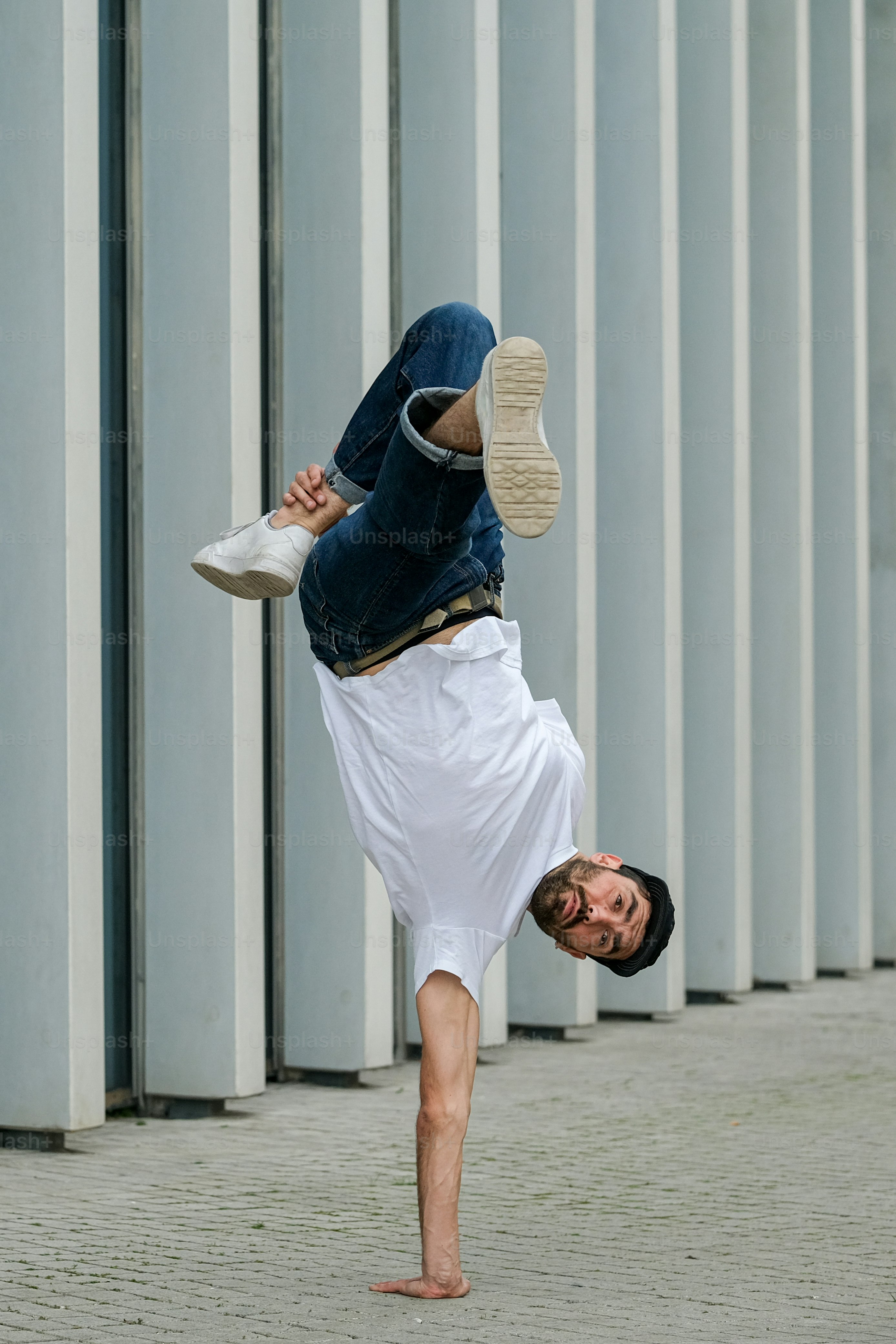 ein Mann macht einen Handstand vor einem Gebäude