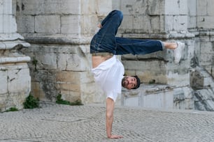 a man doing a handstand in front of a building