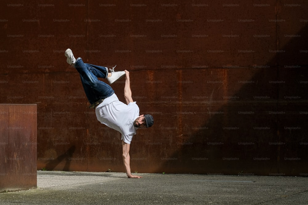 a man doing a handstand in front of a wall