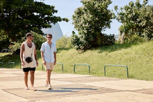 a man and a woman walking on a boardwalk