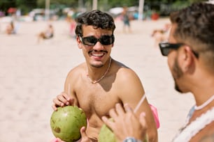 a man holding a coconut and a green drink