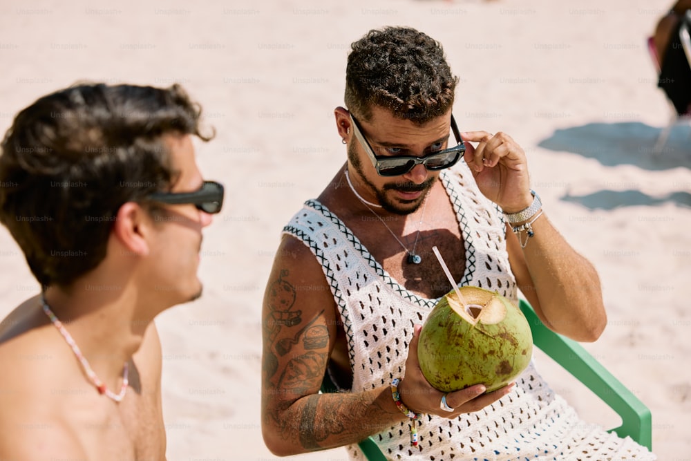 a man in sunglasses is holding a coconut