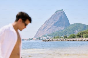 un uomo in piedi in cima a una spiaggia sabbiosa vicino all'oceano