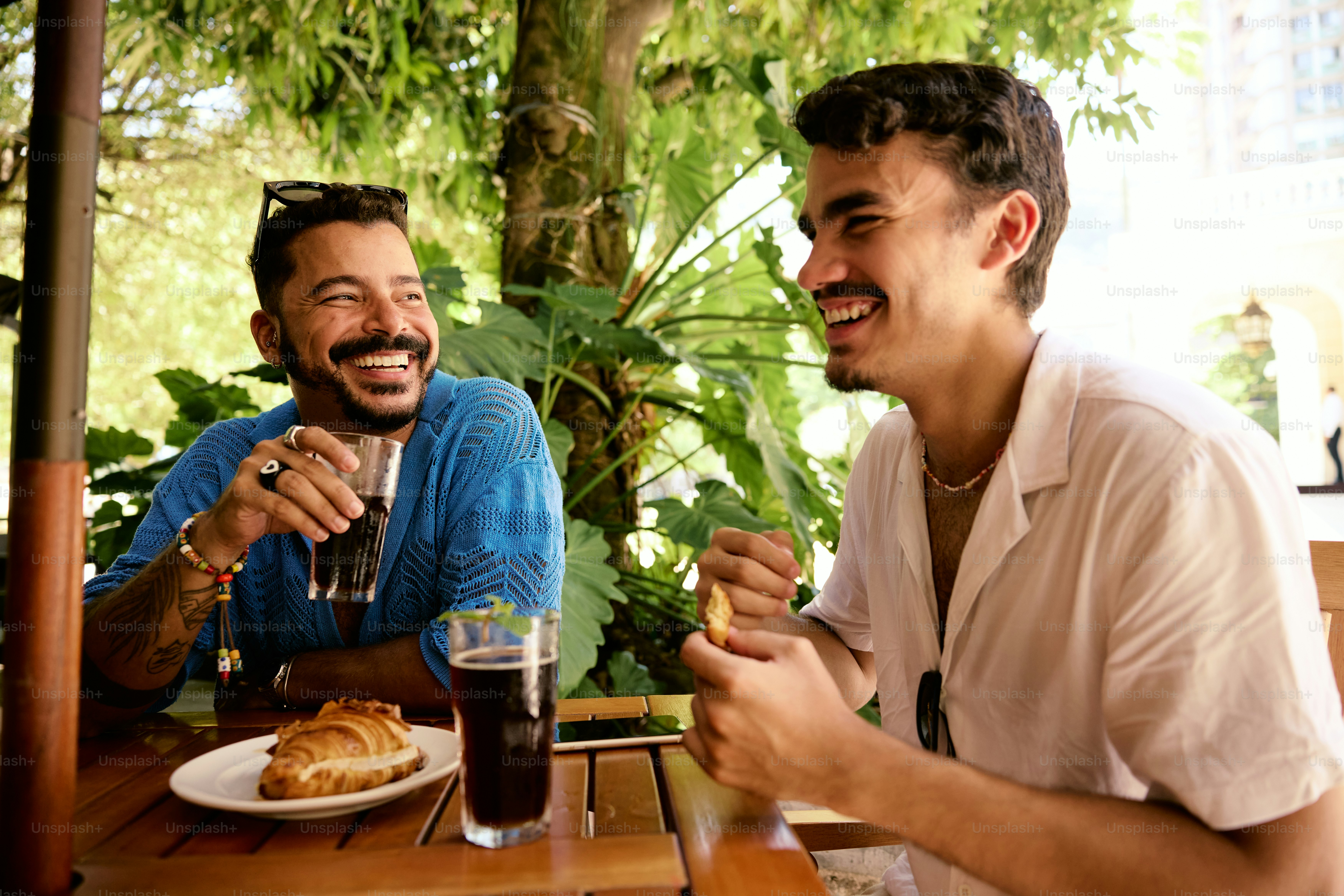 Un par de hombres sentados en una mesa con comida