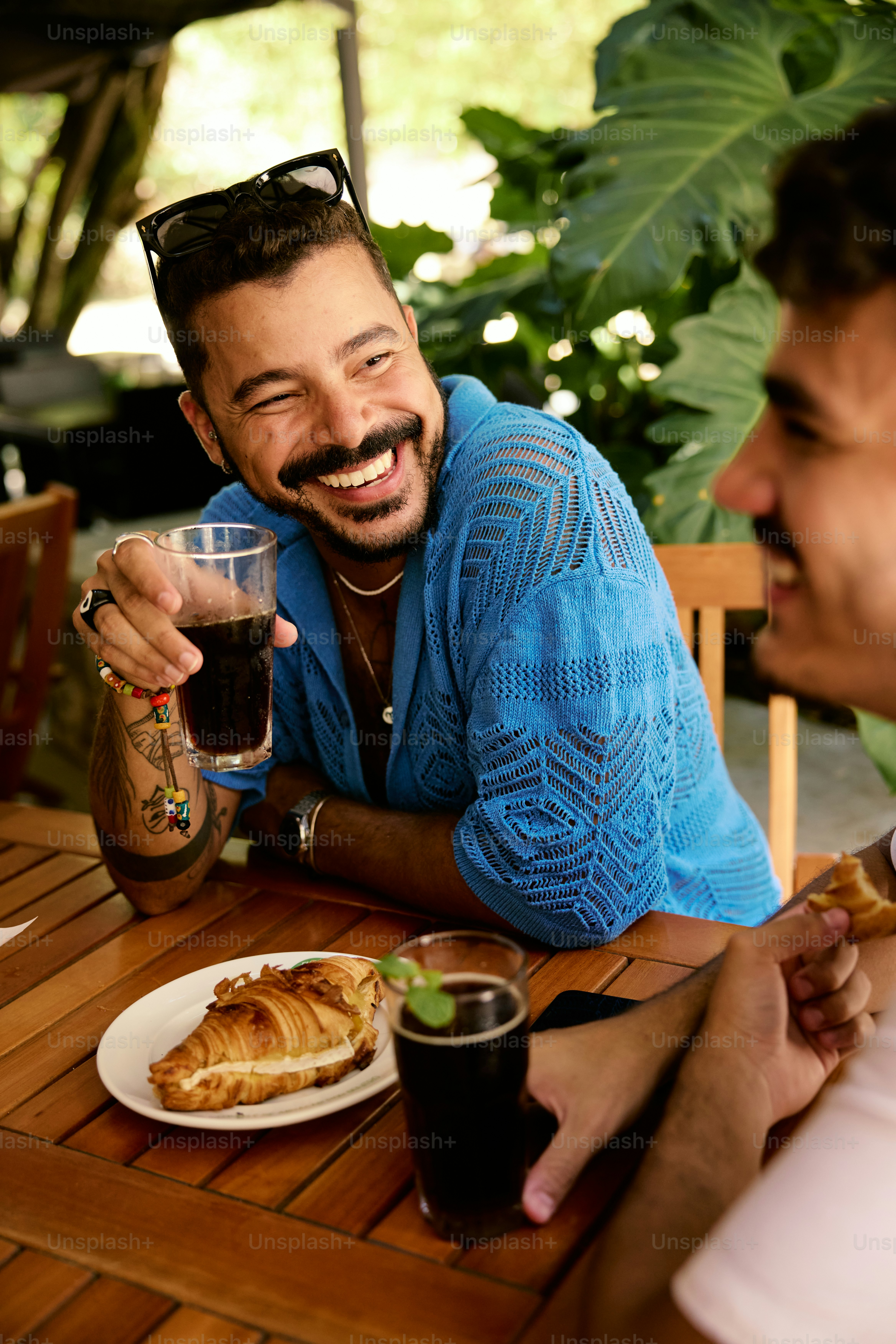 a couple of men sitting at a table with food
