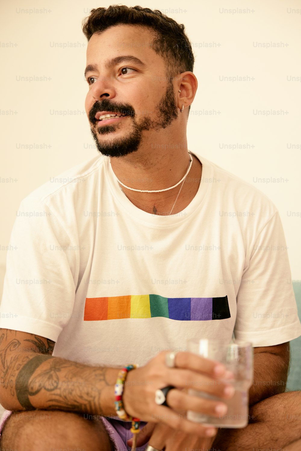 a man sitting on a bed holding a glass of water