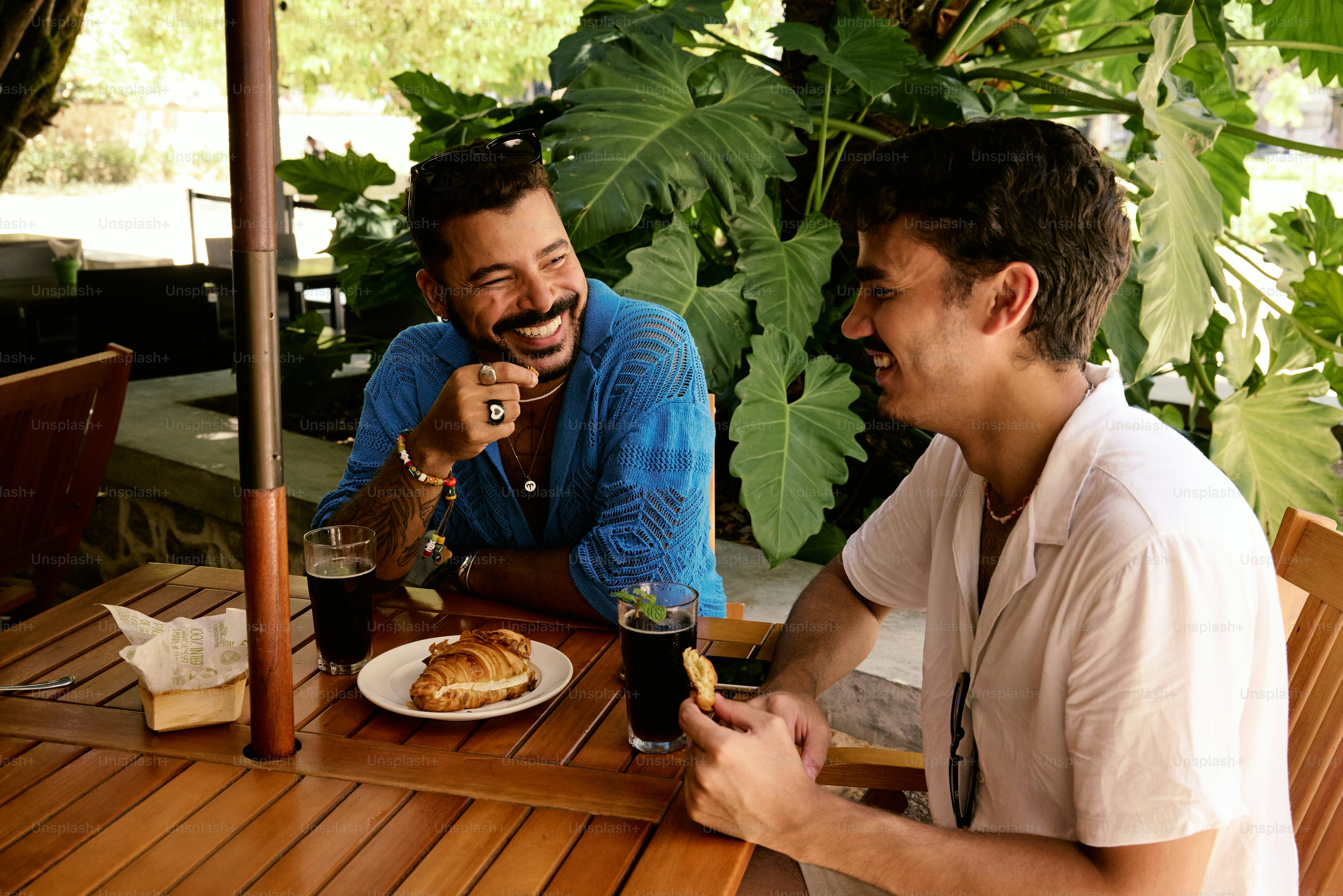 a couple of men sitting at a wooden table