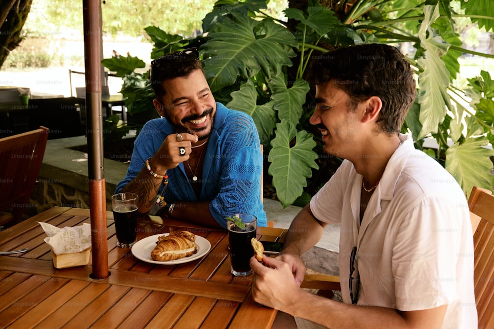 a couple of men sitting at a wooden table