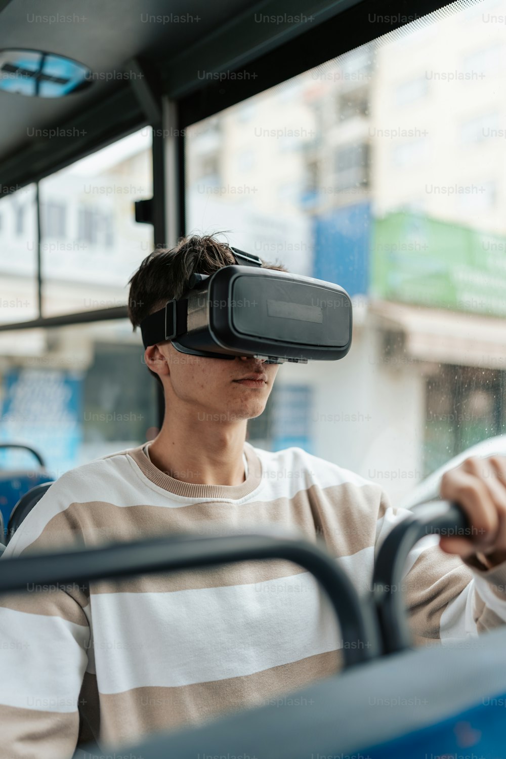 a man wearing a virtual reality headset on a bus