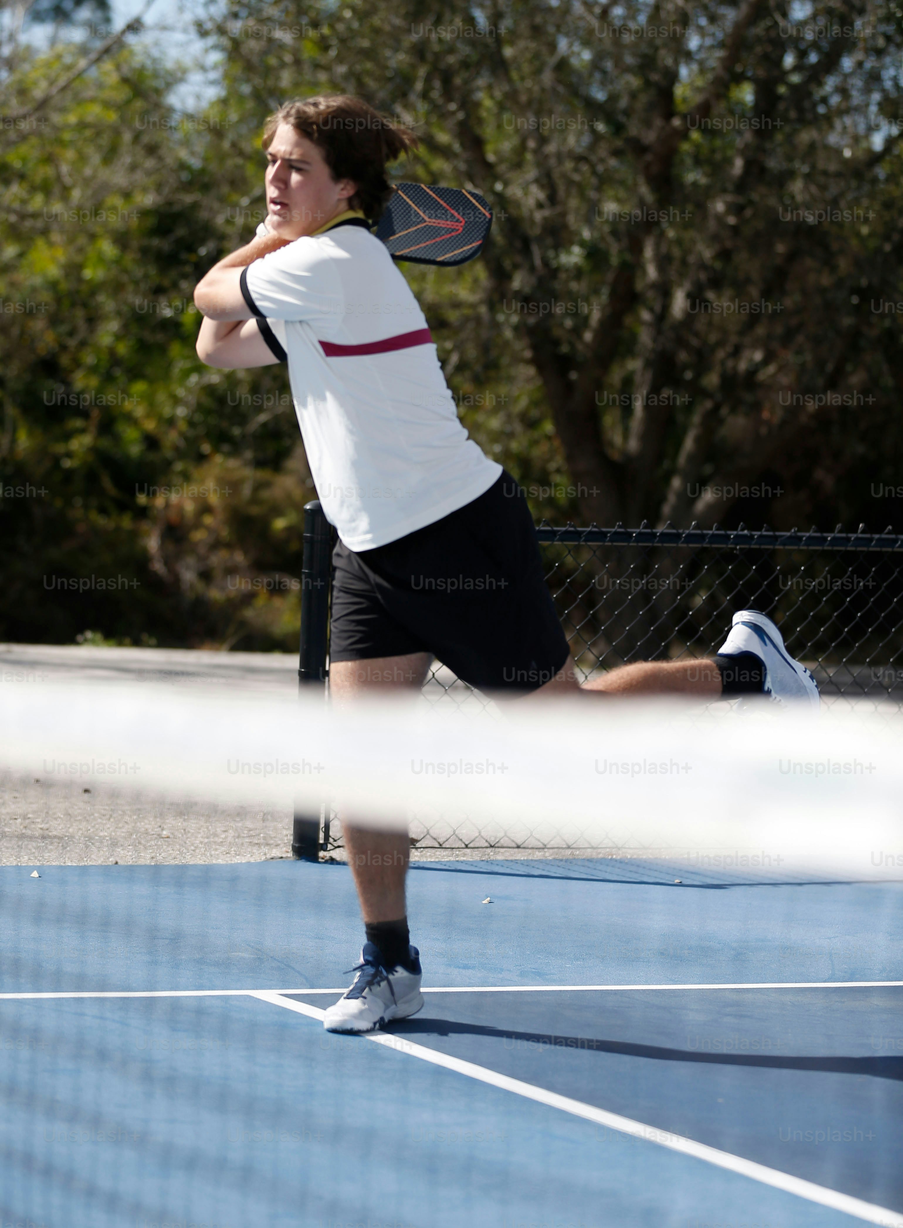 a man swinging a tennis racquet on a tennis court