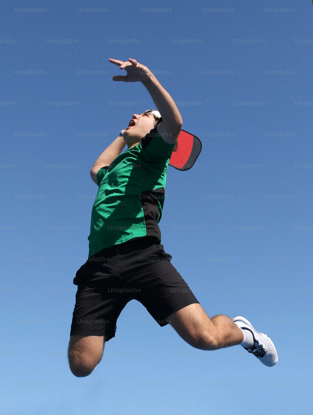 a man jumping in the air to catch a frisbee