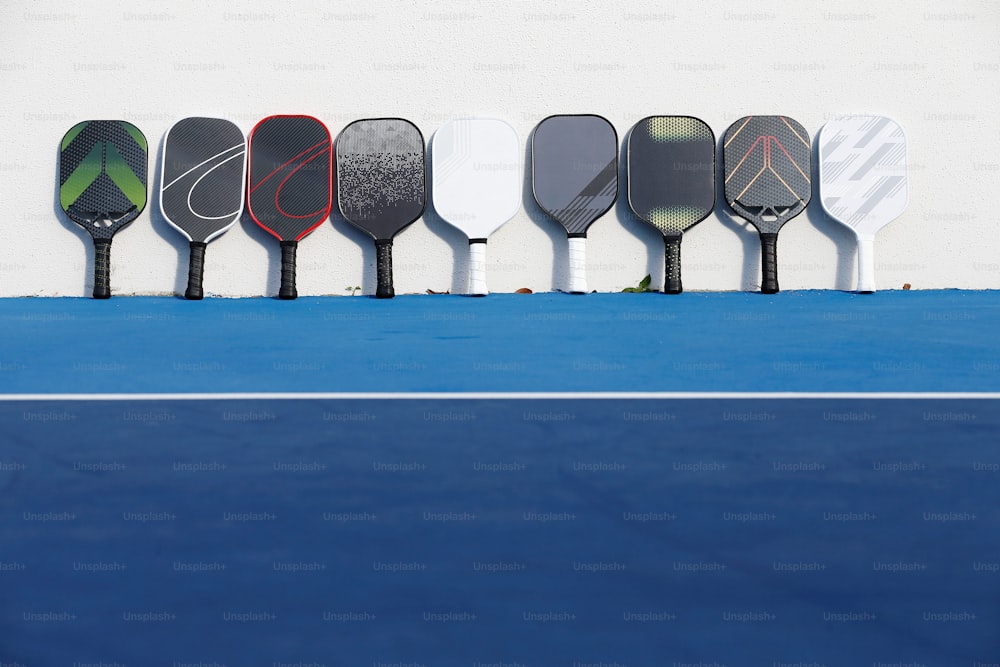 una fila de raquetas de tenis sobre una cancha de tenis azul