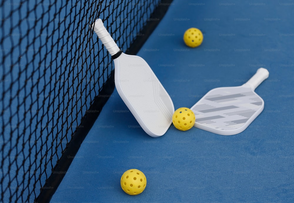 a tennis racquet and ball on a blue court
