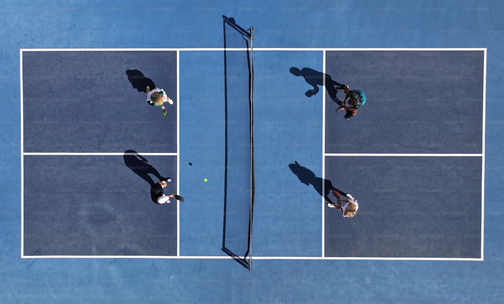 three people standing on a tennis court holding racquets