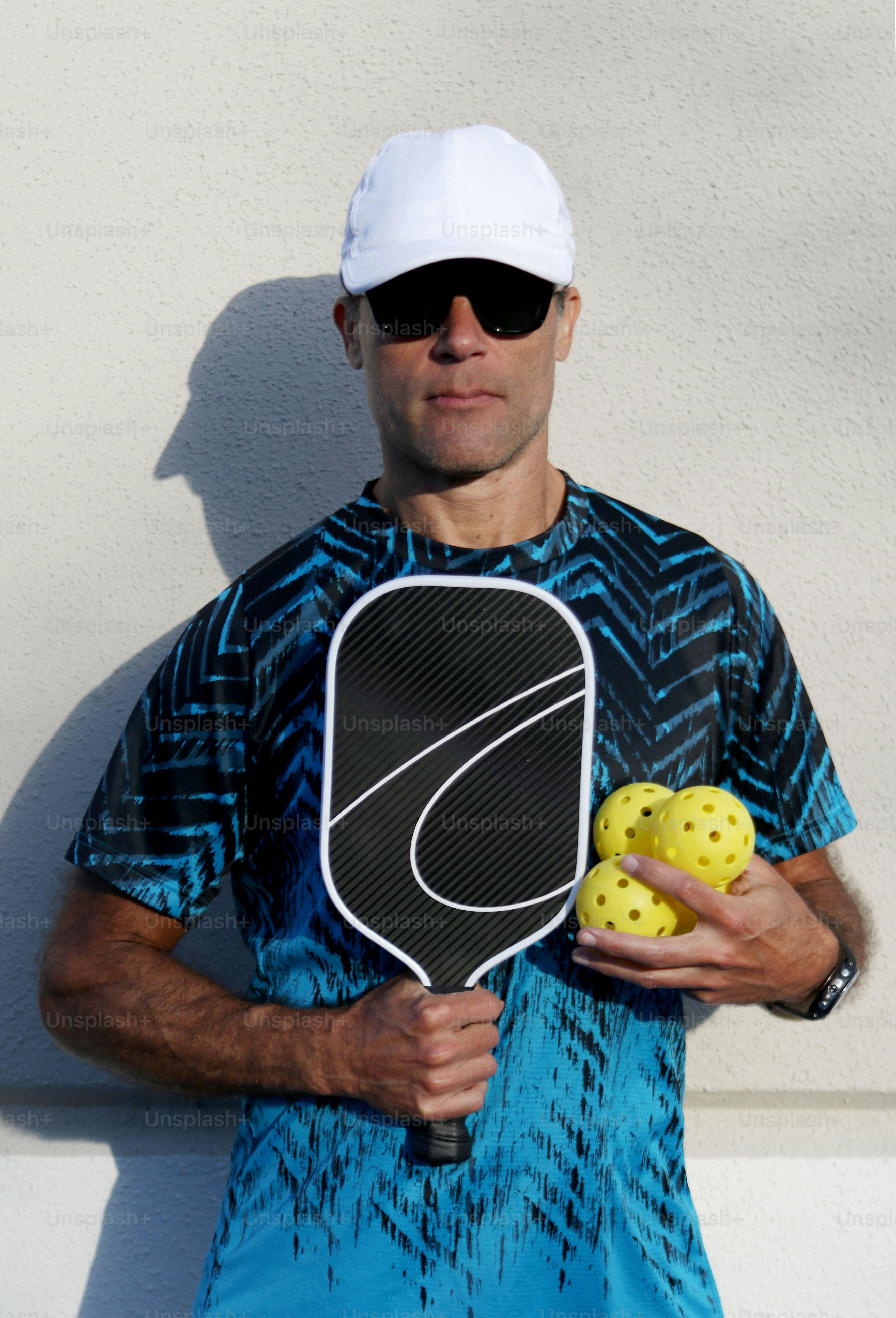 a man holding a tennis racket and a ball