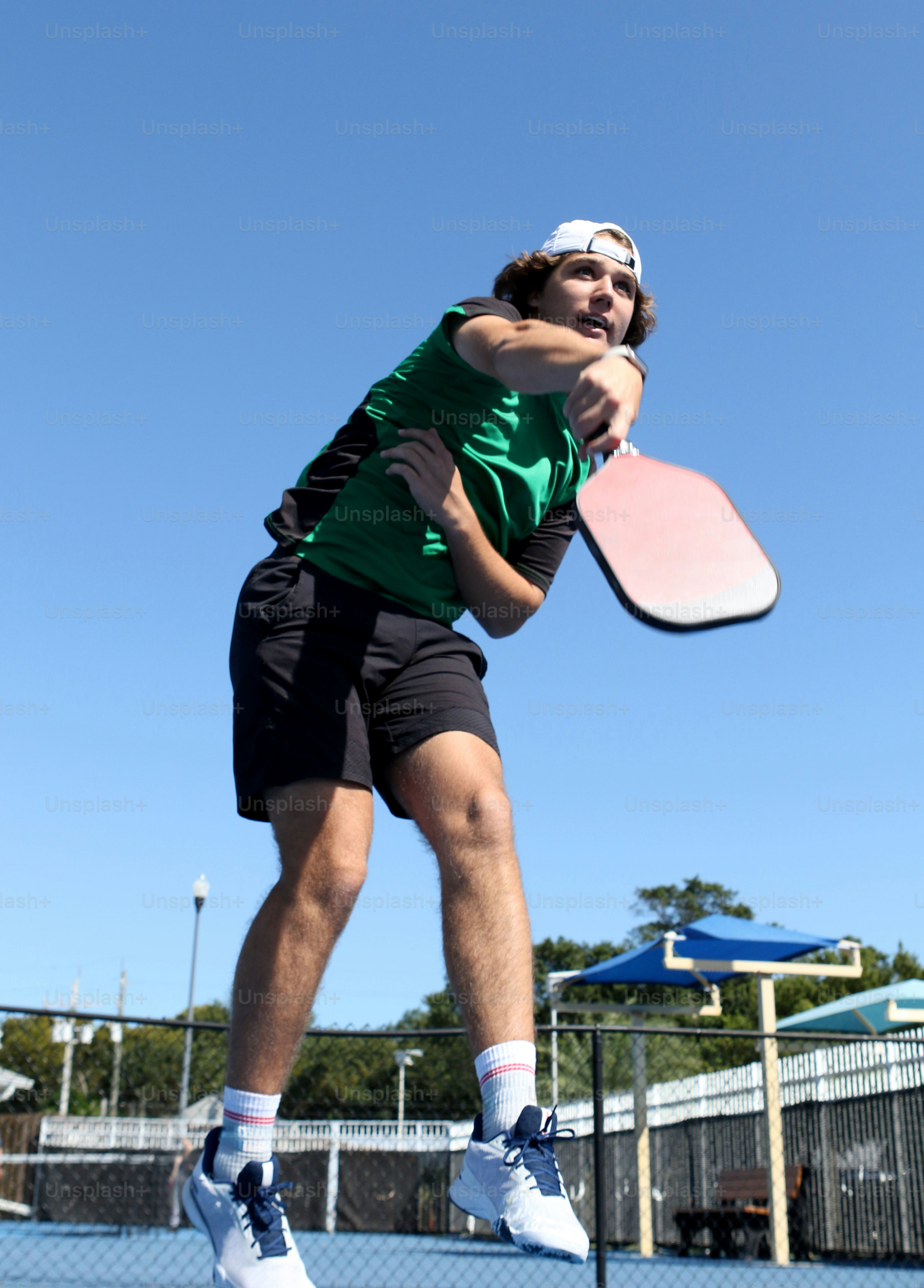 un uomo che salta in aria con una racchetta da tennis