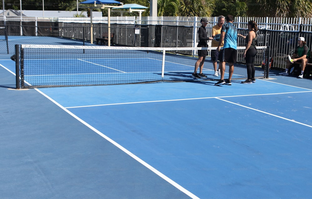 un groupe de personnes debout sur un court de tennis