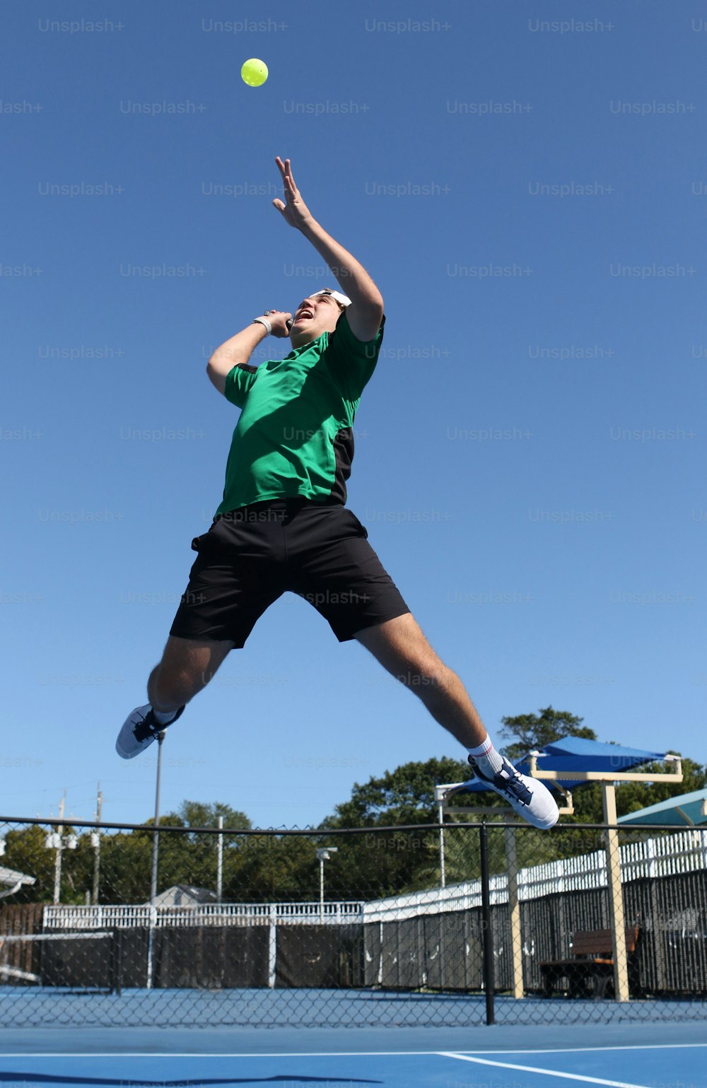 a man jumping in the air to hit a tennis ball