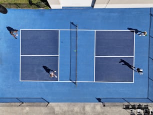 two people playing tennis on a blue tennis court