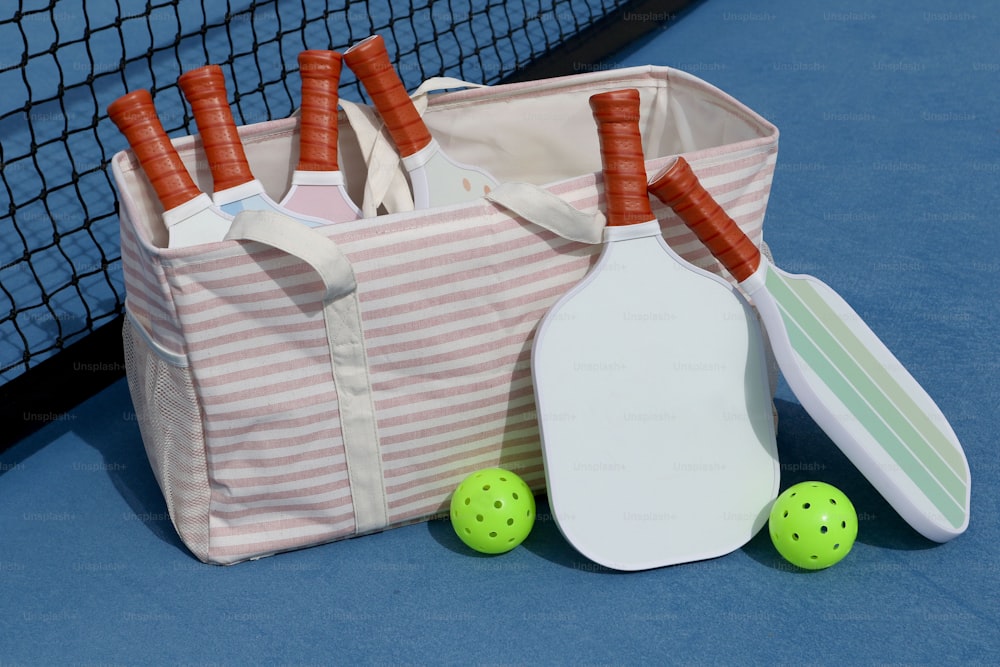 a bag with a tennis racket, ball, and paddle
