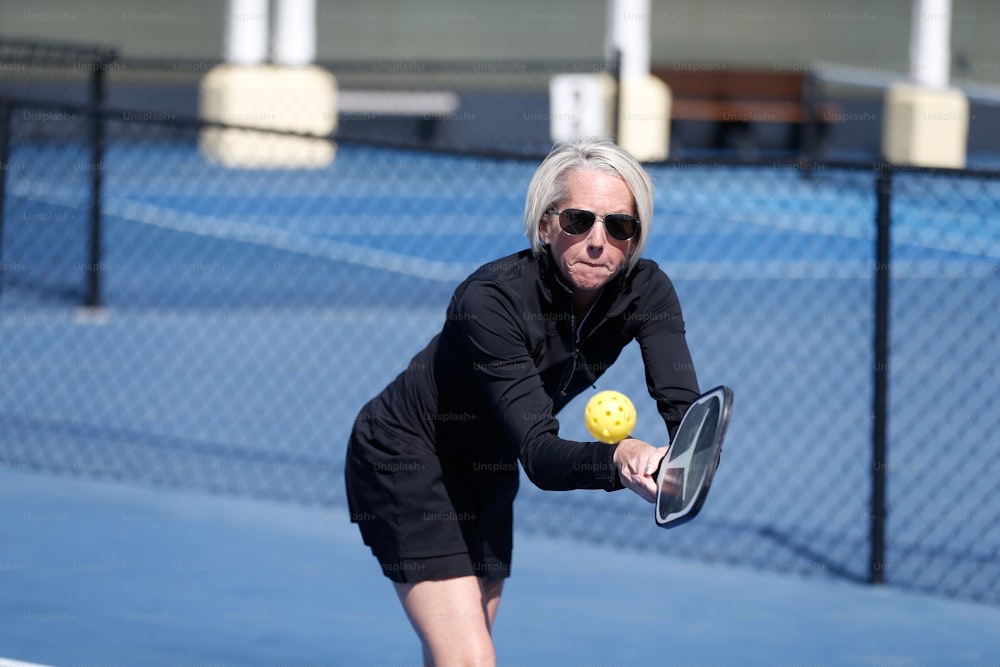 a woman holding a tennis racquet on a tennis court