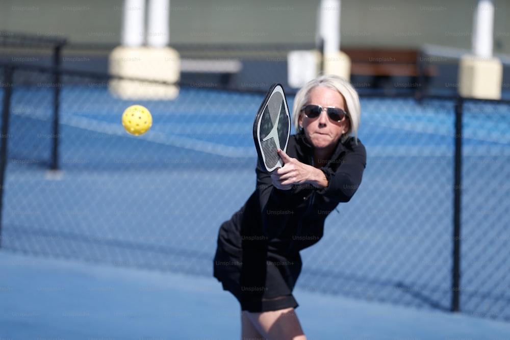 a woman swinging a tennis racquet at a tennis ball
