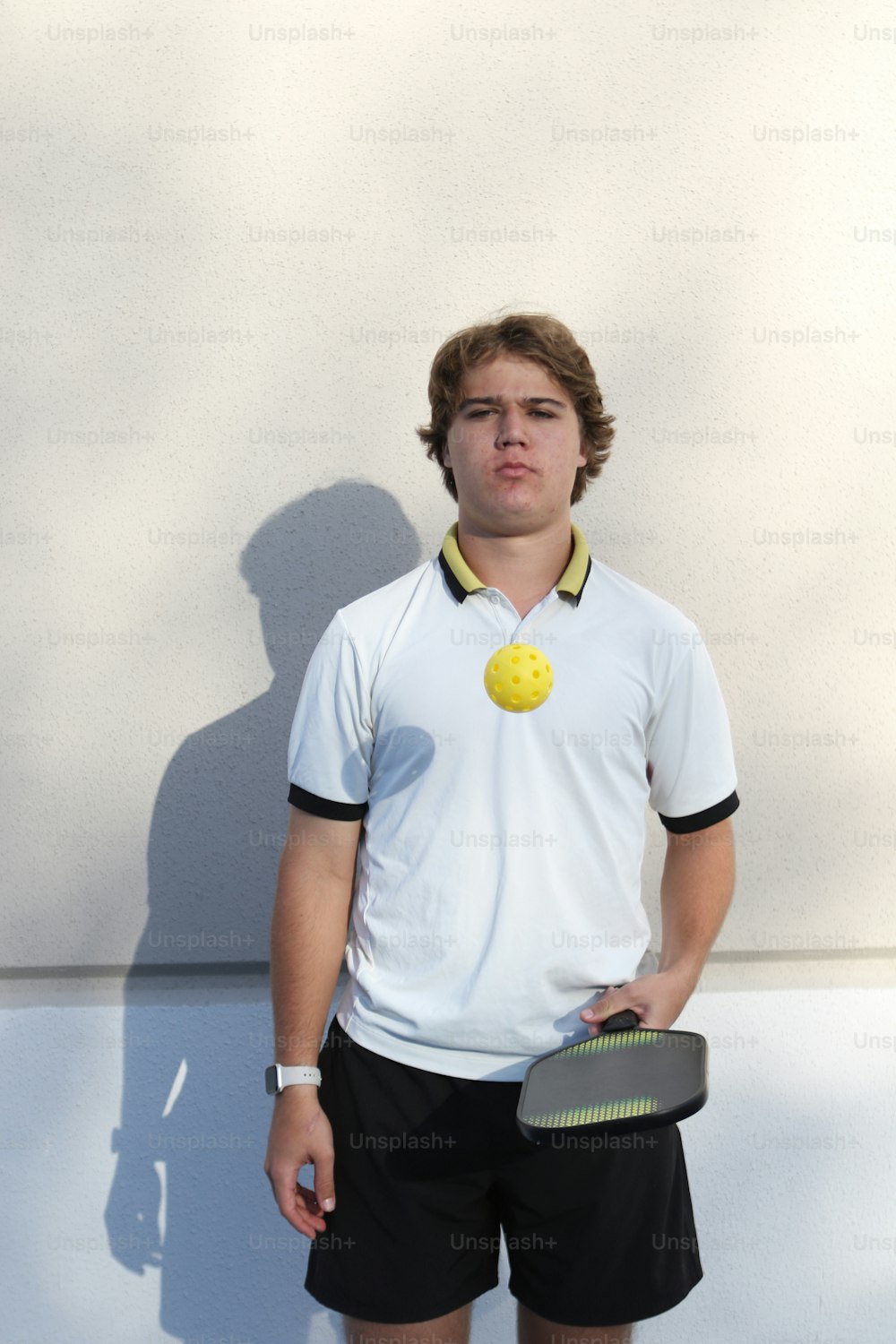a young man holding a tennis racquet and a tennis ball