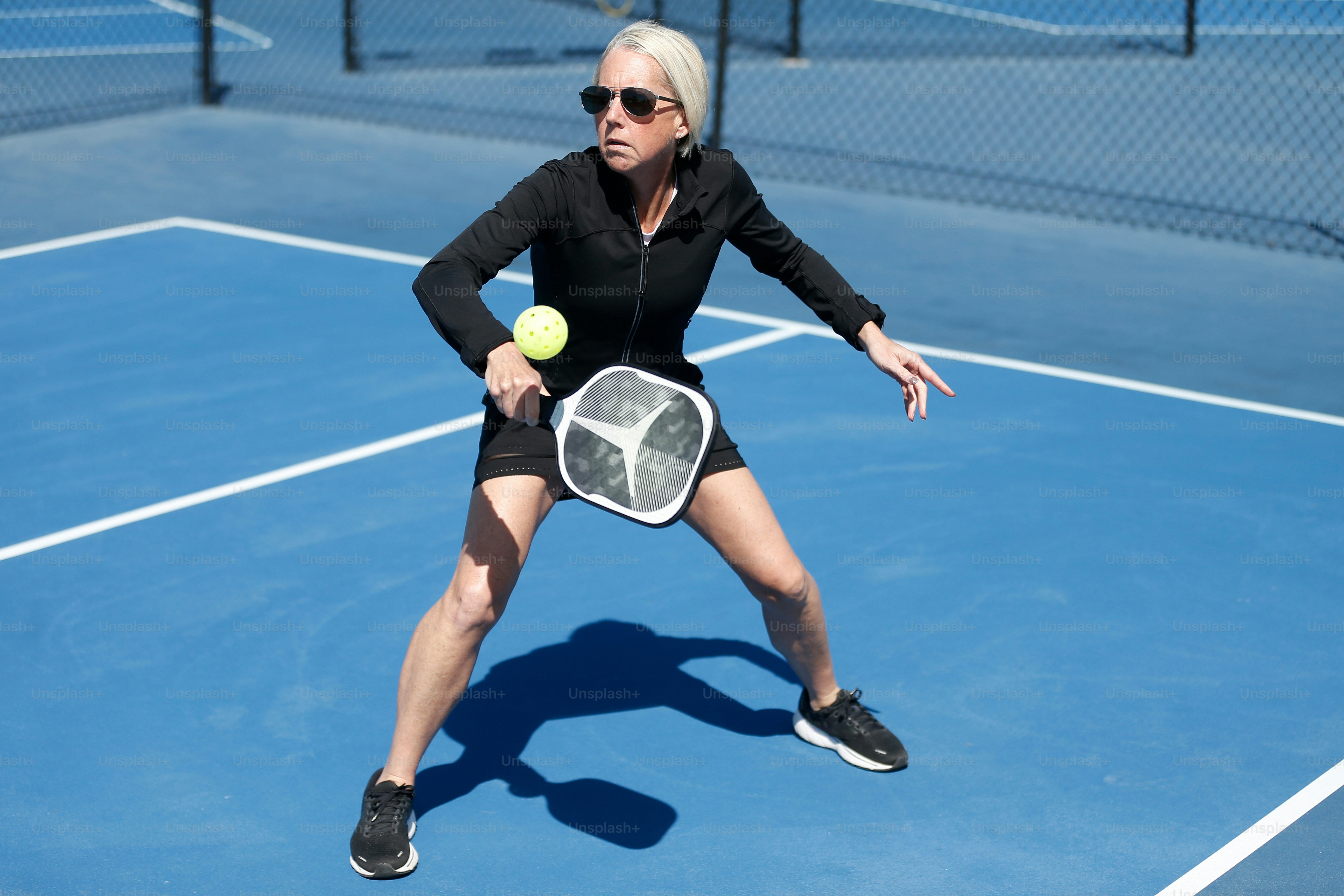 una mujer sosteniendo una raqueta de tenis en una cancha de tenis