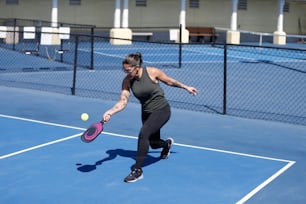 a woman hitting a tennis ball with a racquet