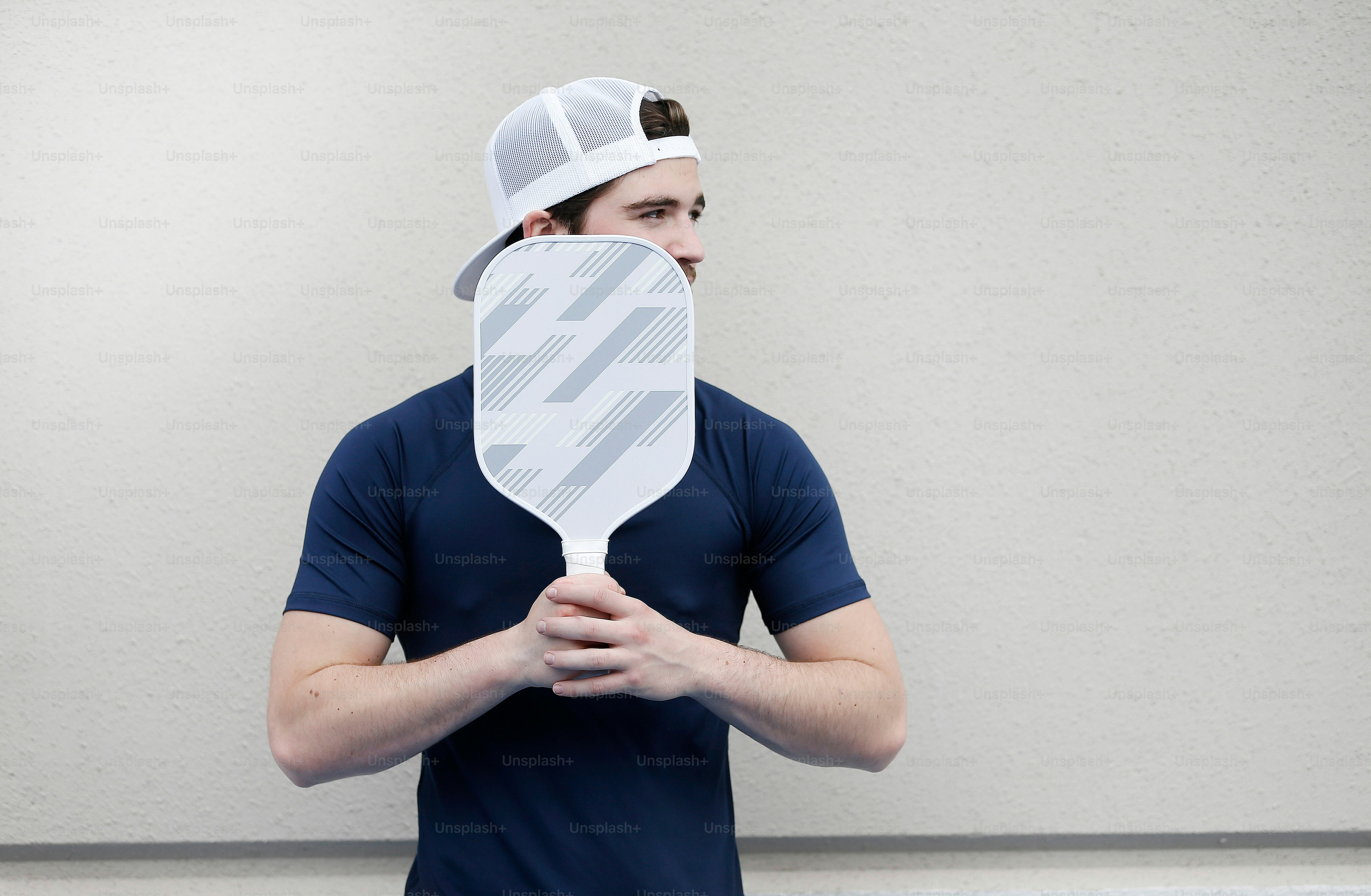 a man holding a paddle in front of his face