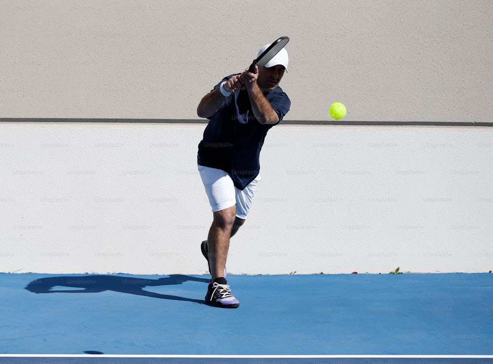 a man swinging a tennis racquet at a tennis ball