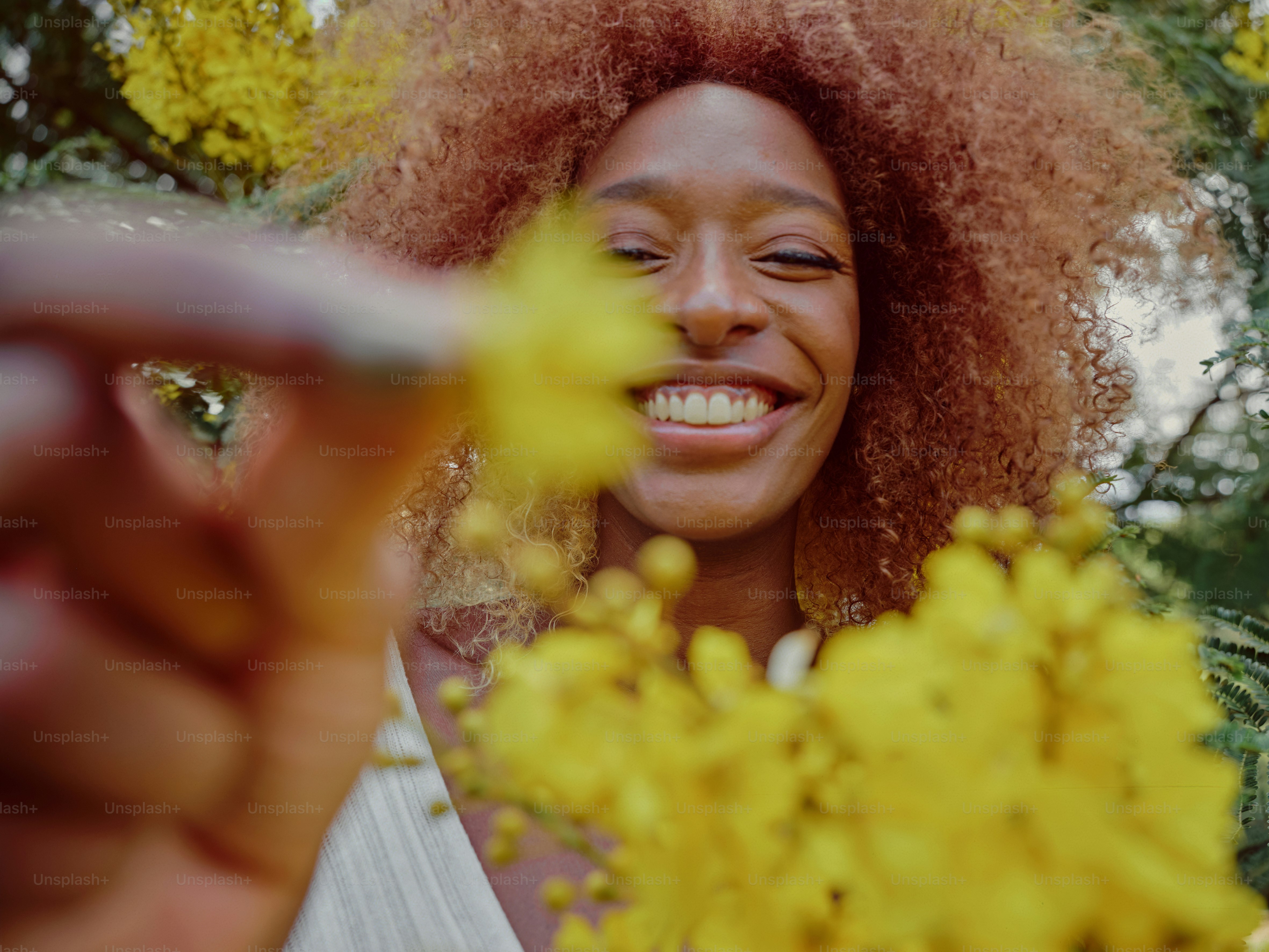 eine Frau, die lächelt und eine Blume in der Hand hält