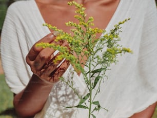 a woman holding a plant in her hands