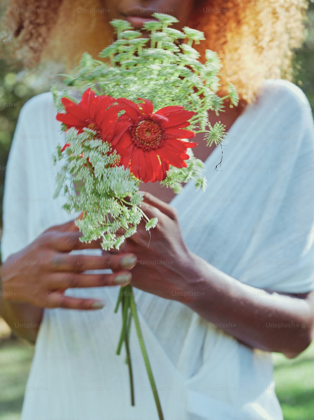 une femme tenant un bouquet de fleurs dans ses mains