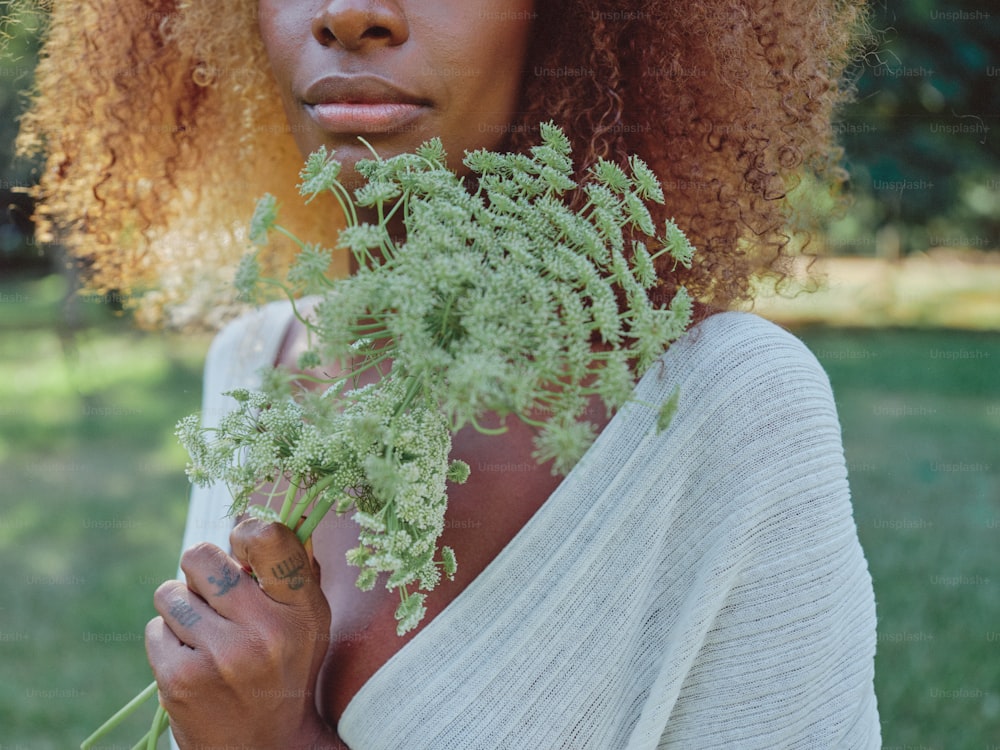 a woman holding a bunch of flowers in her hands