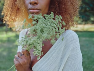 a woman holding a bunch of flowers in her hands