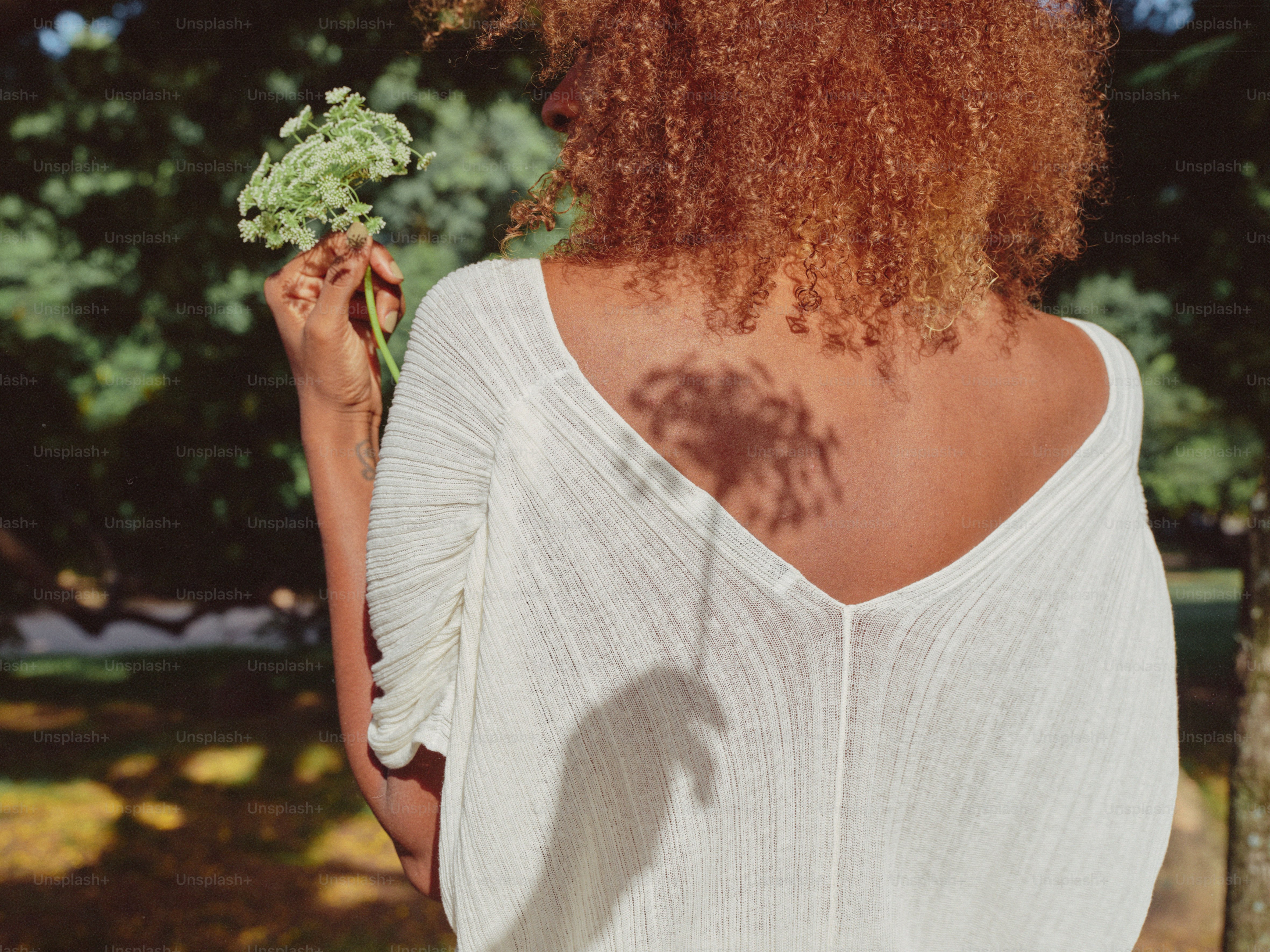eine Frau, die ein Stück Brokkoli in der Hand hält