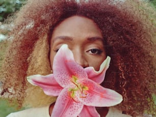 a close up of a person with a flower in their mouth