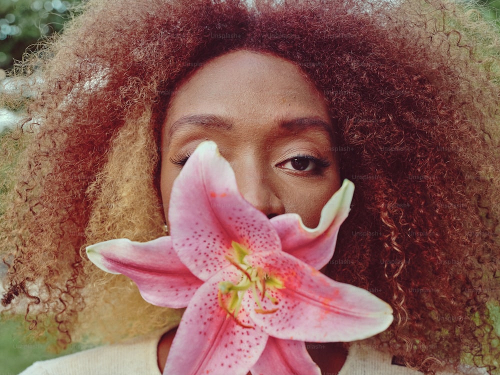 a close up of a person with a flower in their mouth