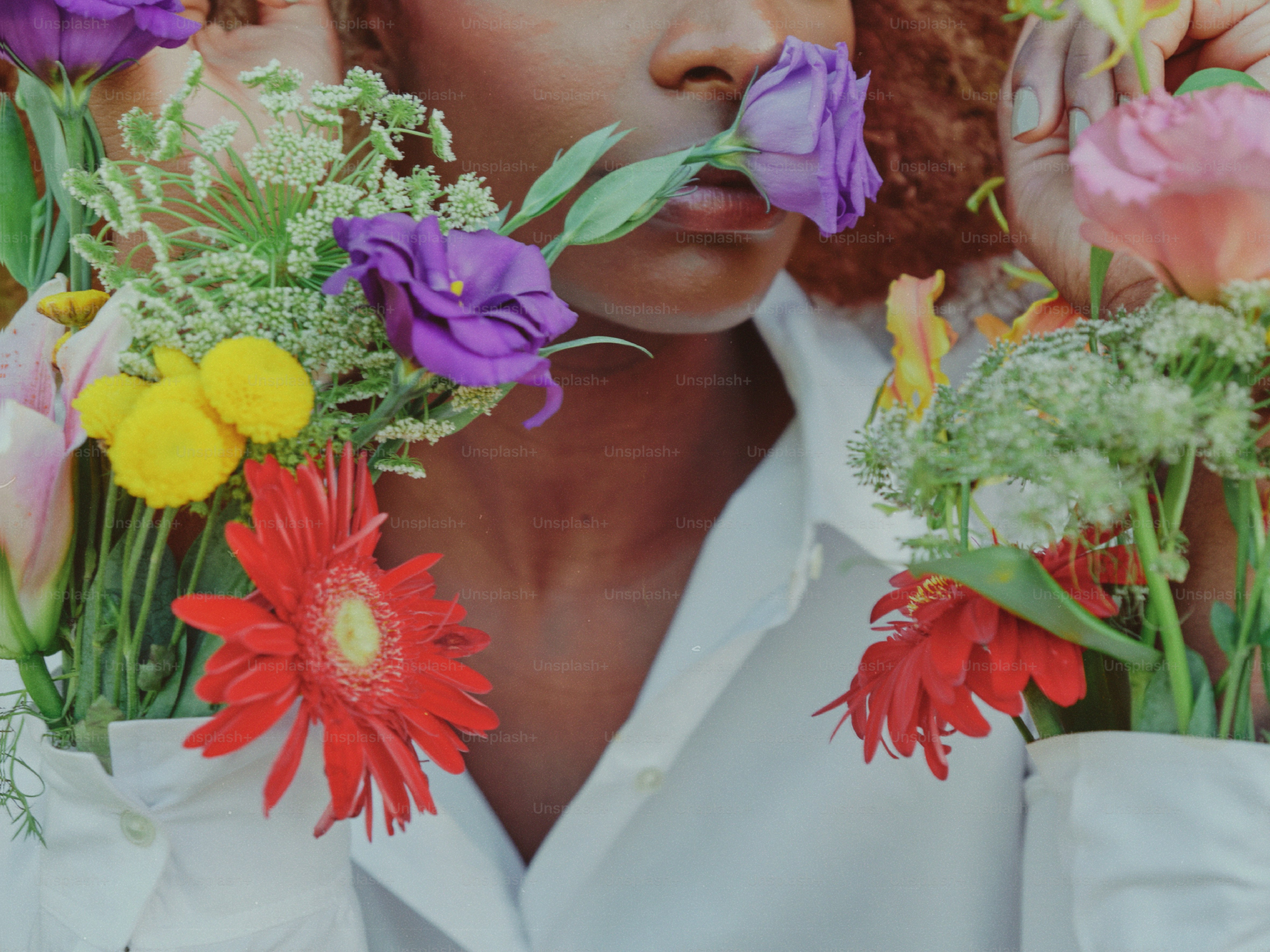 eine Frau, die Blumen vor dem Gesicht hält