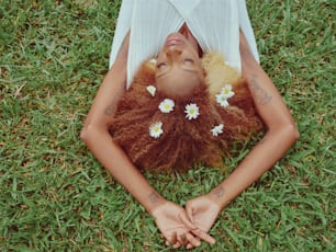a woman laying on top of a lush green field