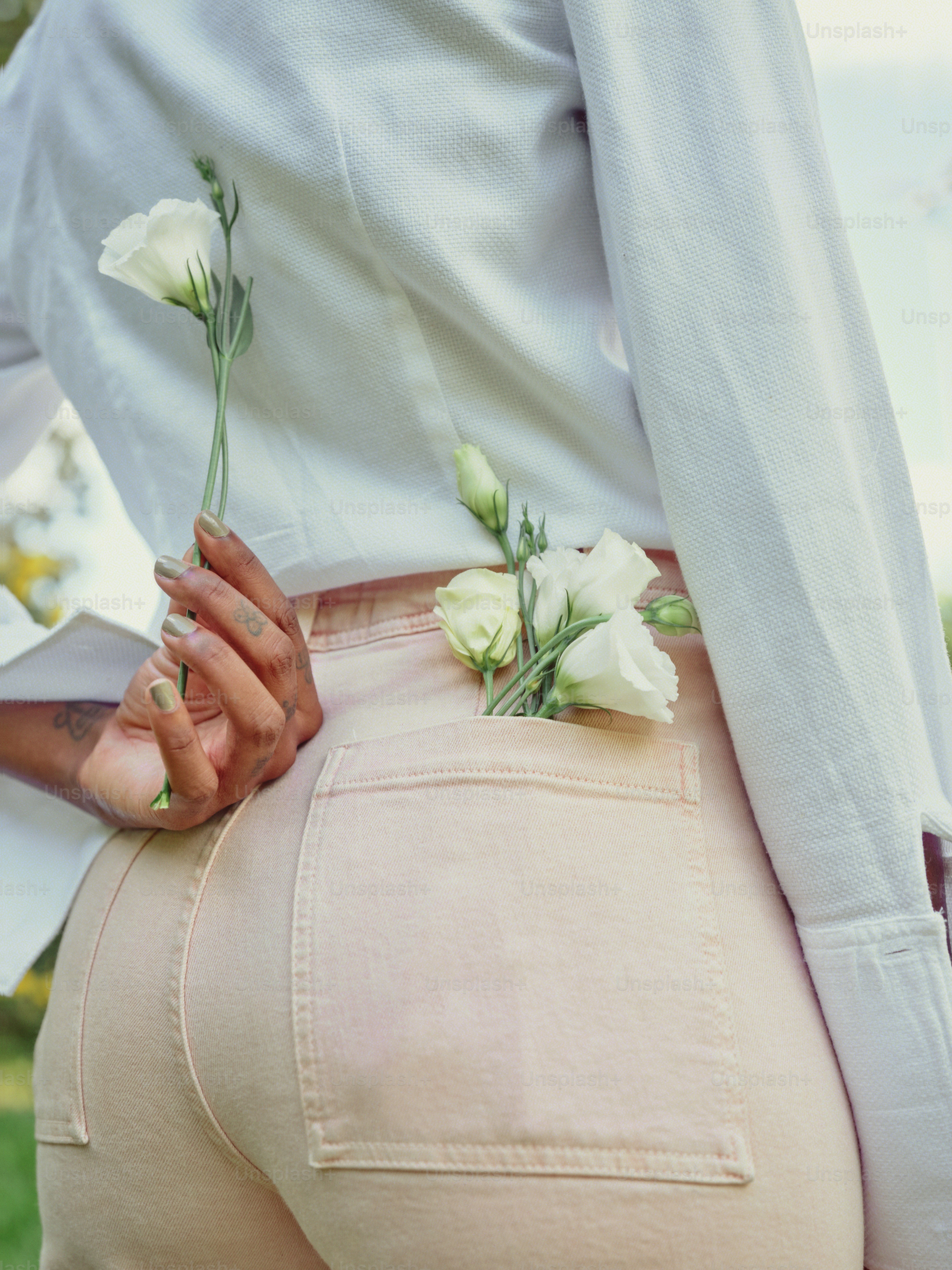 eine Frau trägt ein weißes Hemd und eine rosa Hose