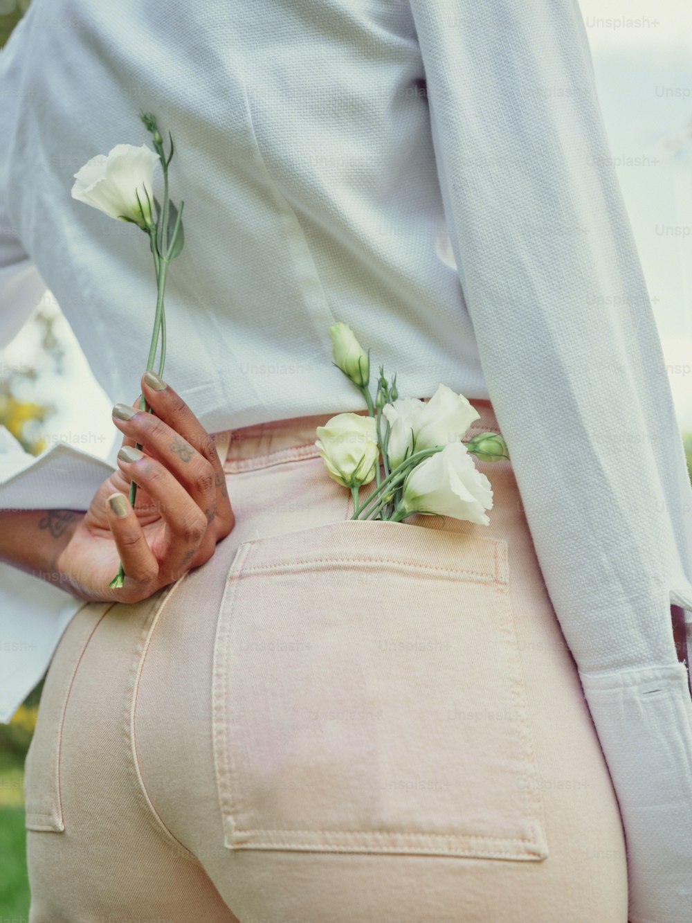 una donna che indossa una camicia bianca e pantaloni rosa