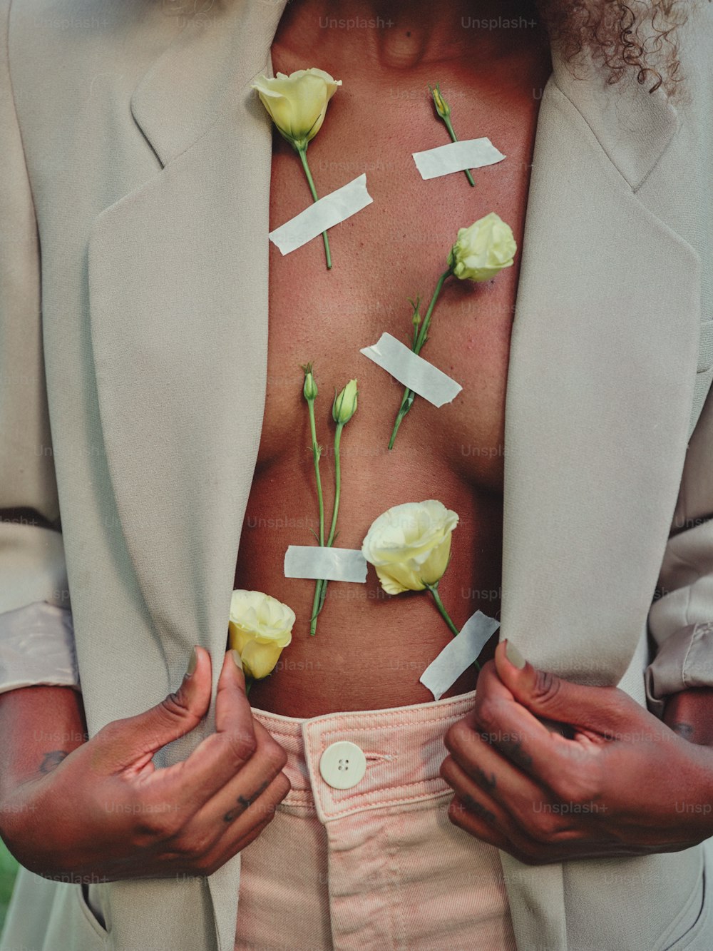 un uomo con dei fiori sul petto e un pezzo di carta attaccato al petto con del nastro adesivo