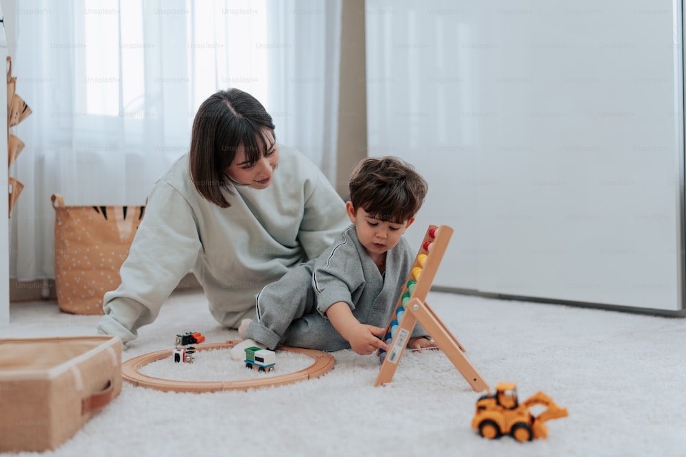 uma mulher e uma criança brincando com brinquedos no chão