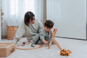 a woman and a child playing with toys on the floor