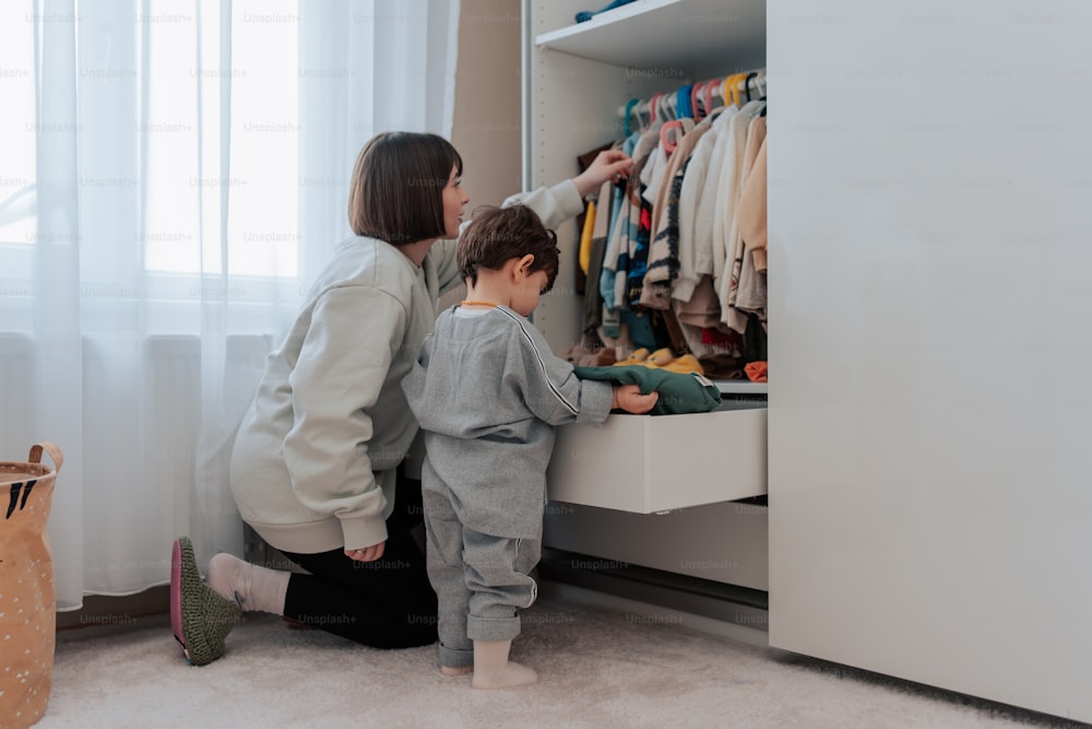 Una donna e un bambino guardano i vestiti in un armadio